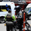 Policía registrando a una persona y verificando su motocicleta.
