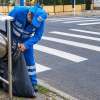 Foto que muestra una persona con el uniforme de LIME haciendo aseo en una caneca para basuras