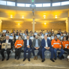Foto que muestra un grupo de personas sentadas en un auditorio 