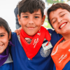 Foto una niña y dos niños sonriendo.