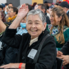 Foto de una señora levantando la mano 