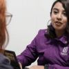 Foto de abogada de la SDMujer, con chaqueta morada, brindando atención jurídica.