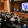 Foto que muestra personas sentadas en un auditorio 