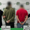 Foto de dos capturados esposados, en medio de dos policías.