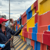 Defensoras del espacio público pintando un bajo puente en Bogotá.