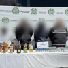 Cuatro de los seis capturados, junto a los elementos incautados, en medio de dos policías.