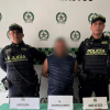 Foto de hombre capturado en medio de dos policías.