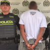 Foto de un hombre capturado en medio de dos policías.