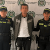 Foto de hombre capturado en medio de dos policías.