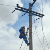 Trabajador de Enel subido en un poste de luz durante labores de mantenimiento.