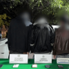 Foto de cuatro capturados esposados, de espaldas.