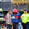 Foto de dos capturados esposados.