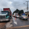 Vehículos particulares y de carga avanzan por una avenida de Bogotá con tráfico lento y carriles parcialmente ocupados en Bogotá.