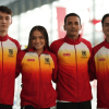 Cuatro deportistas del Equipo Bogotá posan juntos en una instalación deportiva cubierta. Llevan chaquetas de equipo con degradado rojo, naranja y amarillo, cremallera frontal y los textos visibles ‘IDRD’ y ‘Alcaldía Mayor de Bogotá D.C.’ en el pecho.