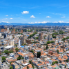 Vista panorámica de Bogotá desde gran altura, con una amplia zona urbana compuesta por viviendas de teja roja, edificios residenciales y vías vehiculares.