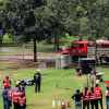 Personal de atención de emergencias y gestión del riesgo participa en un ejercicio de coordinación en una zona verde con conos de señalización, mientras un vehículo de emergencia permanece ubicado al fondo del parque Simón Bolívar en Bogotá.