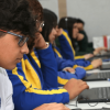 Foto que muestra estudiantes escribiendo en un computador 