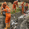Foto que muestra personas con el uniforme de Aguas Bogotá limpiando una quebrada