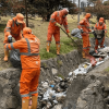 Foto que muestra personas con el uniforme de Aguas Bogotá limpiando las calles