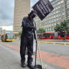 Imagen de un hombre vestido con overol azul recogiendo los residuos de la calle. De fondo se ve la carrera Décima de Bogotá.