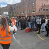 Grupo de personas reunidas en una cancha deportiva durante un ejercicio de simulacro en Bogotá. En primer plano, varias personas usan chalecos reflectivos naranjas mientras orientan a los participantes.