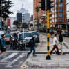 Foto que muestra carros y personas caminando por la calle