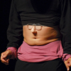 Imagen del cuerpo de un hombre que viste de negro y su estómago está descubierto.