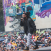 Imagen de un artista en la tarima de Hip Hop al Parque de fondo se ven muchos asistentes.