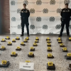 Foto de dos policías frente a paquetes de mariuana incautados en el aeropuerto.