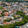Foto panorámica de una amplia zona urbana con un estadio, edificios, casas y áreas verdes.