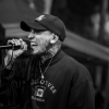 Foto de Kain Anmistía cantando con una gorra oscura