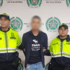 Foto de hombre capturado en medio de dos policías.