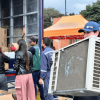 Personas entregan y descargan equipos electrónicos y cajas de cartón durante Reciclatón 2026 de residuos posconsumo, frente a un camión de carga habilitado para recibir los materiales.