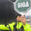 Foto de un militar con un letrero que dice: Siga en color verde 