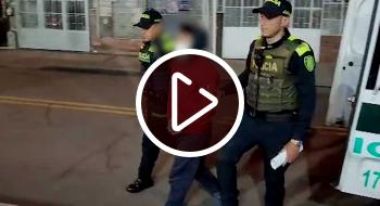 Una persona de rojo capturada por una mujer policia y un policia hombre